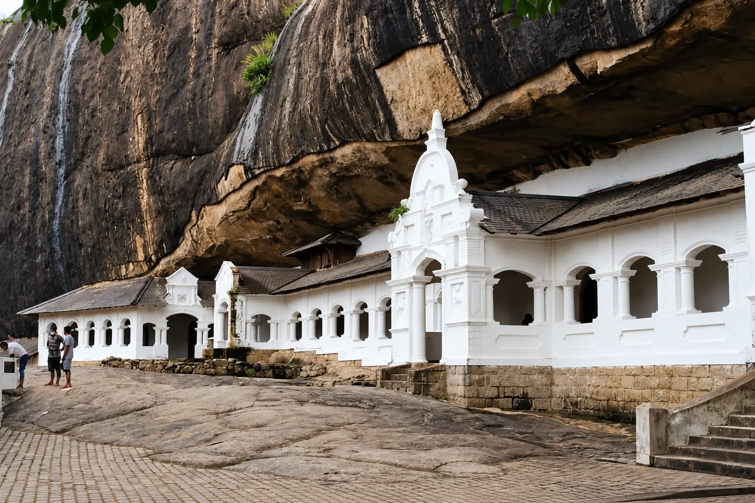 The whitewashed colonnade along the rock face at the entrance to the Dambulla cave temples